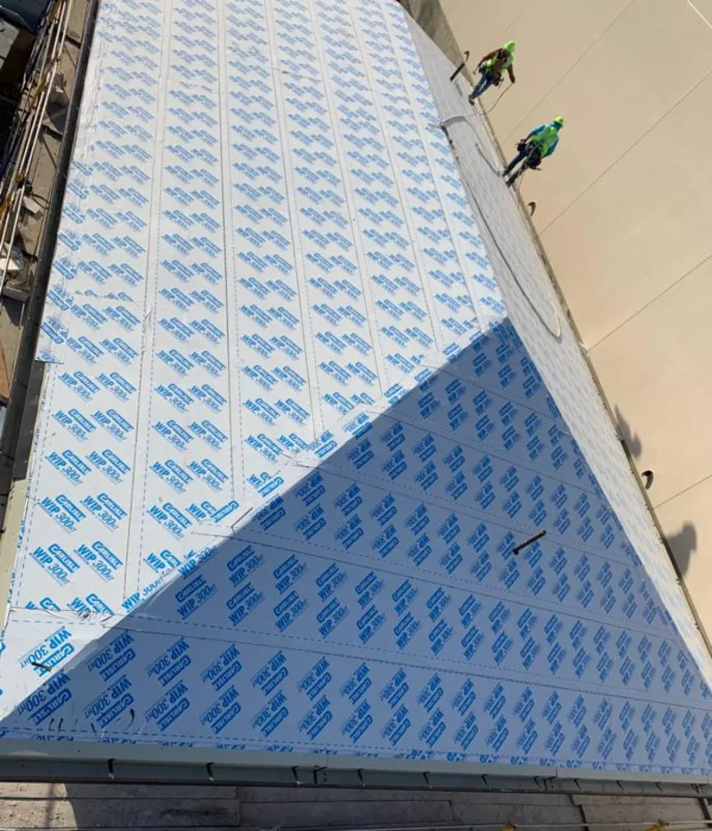 Professional roofers installing underlayment on a metal roof in Orem